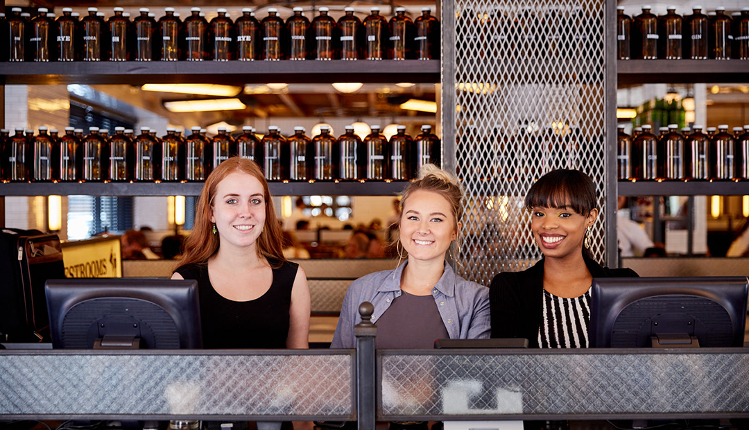 A photo of three hosts at the front door of The Smith NoMad