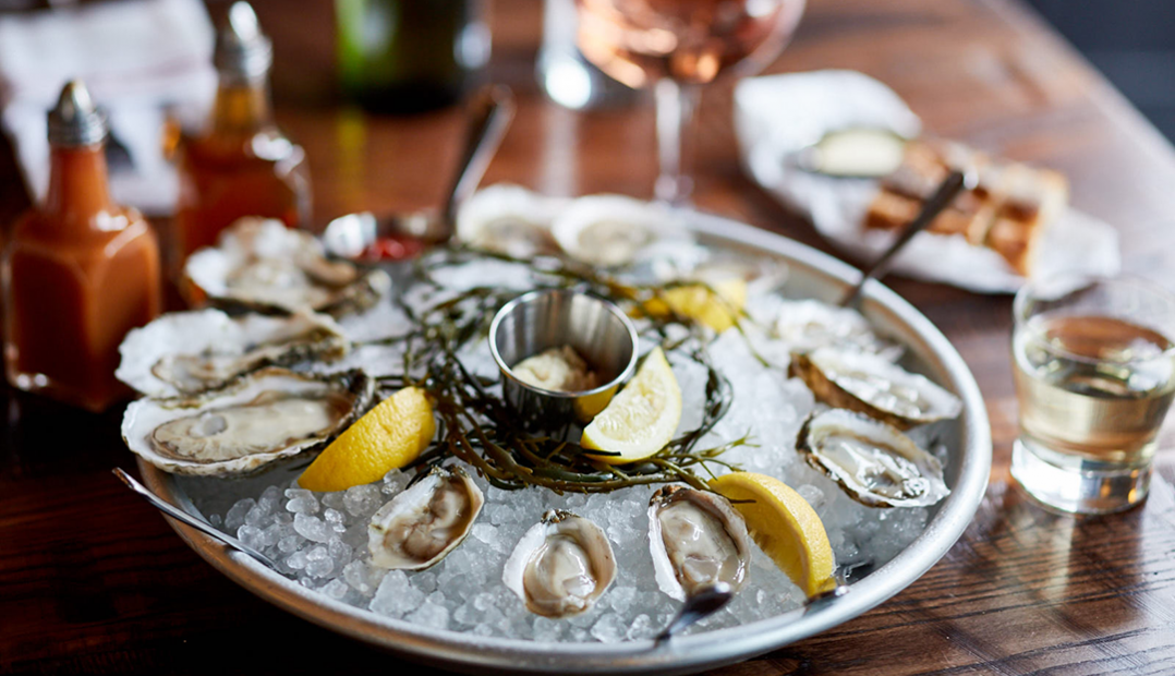 A photo of a dozen oysters at The Smith with hot sauce and mignonette.