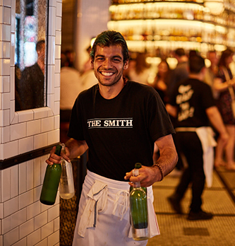 A photo of a runner holding bottles of water at The Smith.